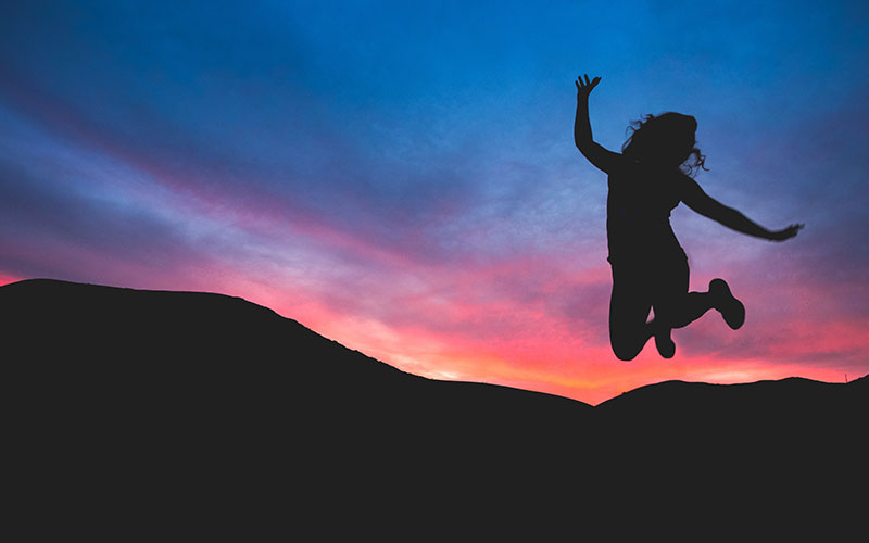 Silhouette of woman jumping in celebration