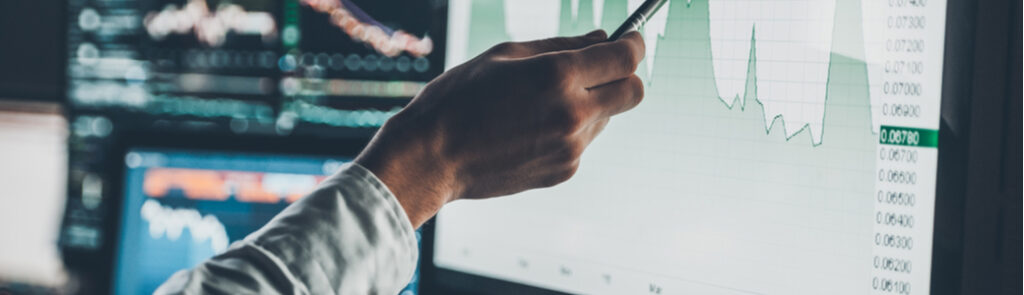 A man pointing to a screen showing data on a chart