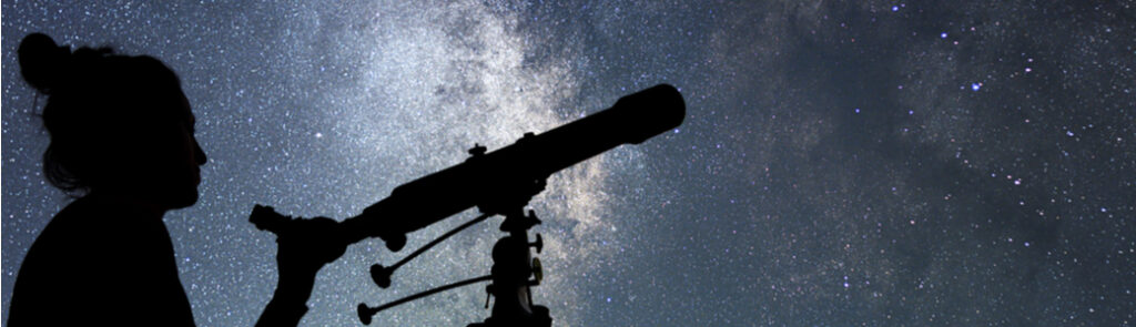 A woman with a telescope stargazing