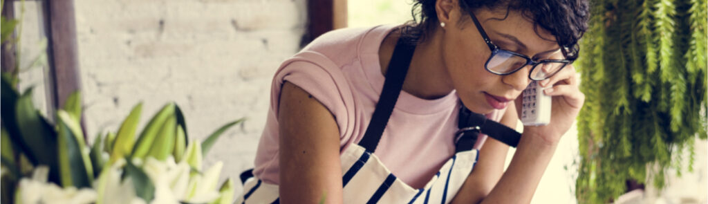 A woman on the phone in a florist.