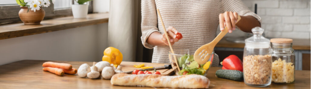 A person making a salad with fresh ingredients