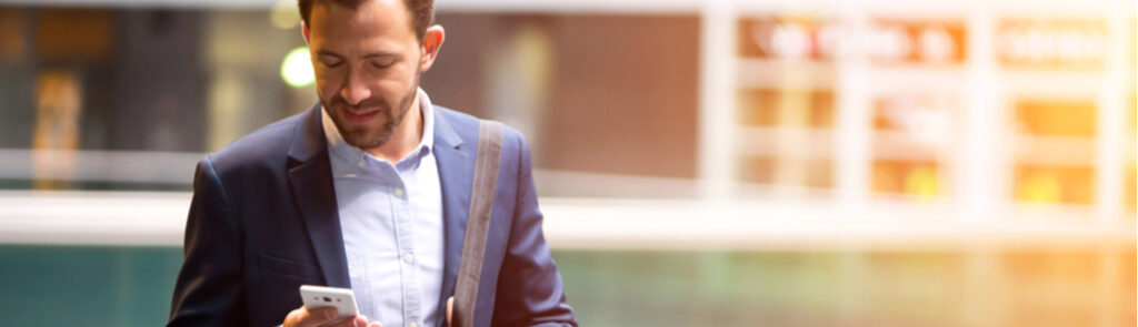 A man walking and using his smartphone.