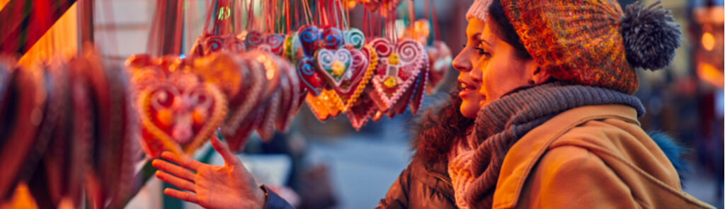 Two women looking at a Christmas market stall.