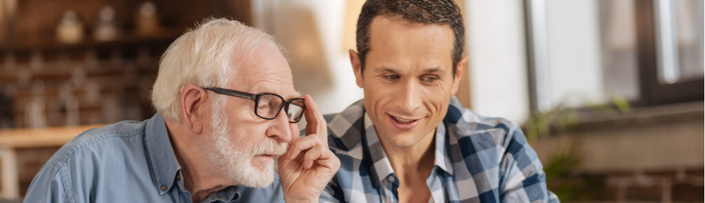 Young man showing his elderly father something on a tablet