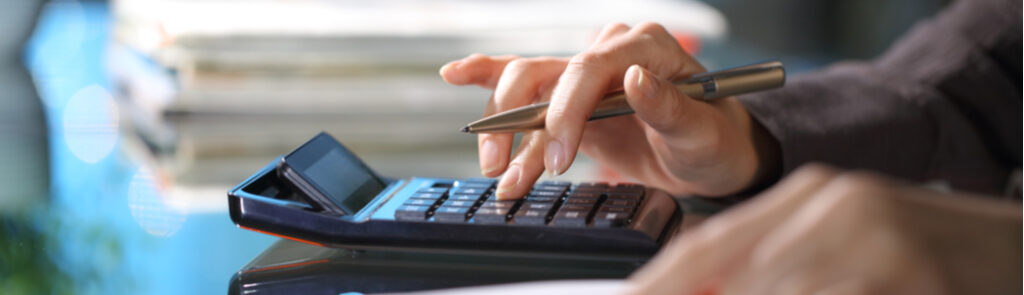 Close-up of a person using a calculator.