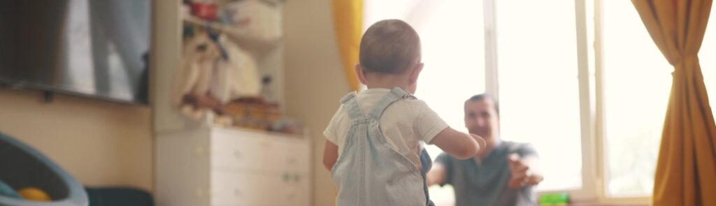 A toddler walking towards a parent.