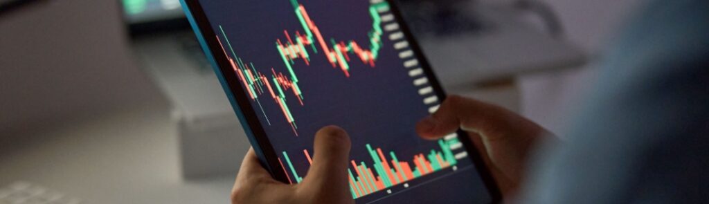 A person looking at a stock market graph on a tablet.