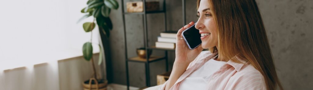 A woman talking on the phone at home.