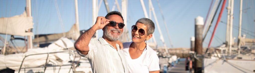 A couple posing on a marina pier.