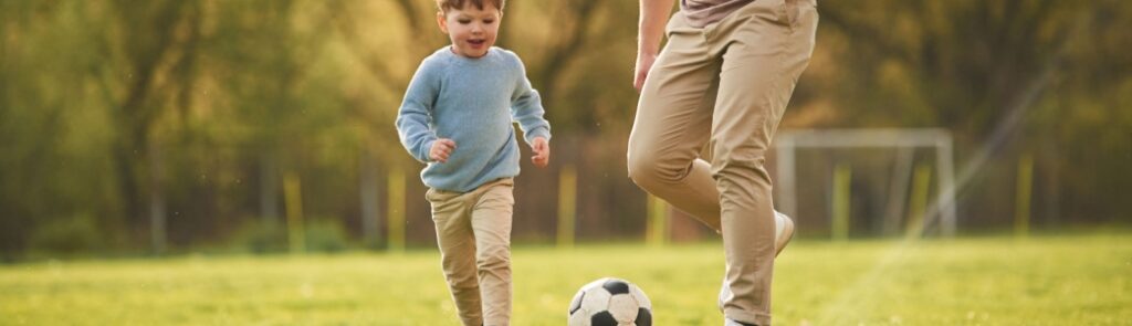 A father playing football with his young son.