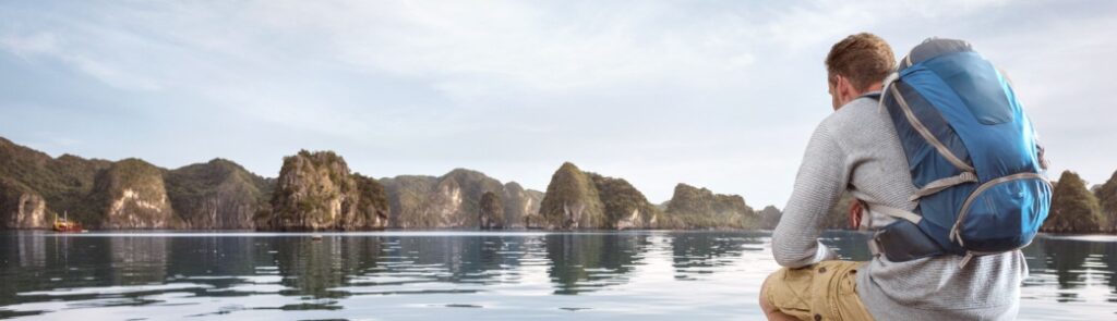 Traveller crouching on a jetty.