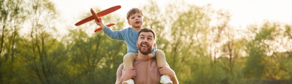 A father with a child sitting on his shoulders.