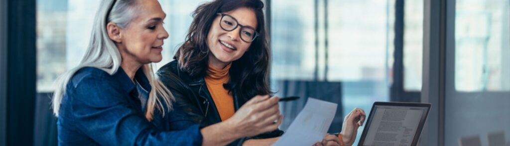 A woman talking to a colleague in an office.