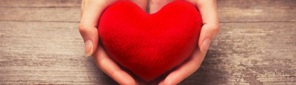 Close-up of hands holding a red heart