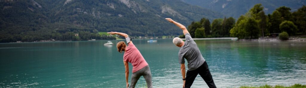 Couple doing tai chi by a lake