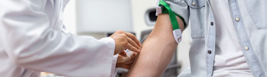 A doctor preparing to draw blood from a man.