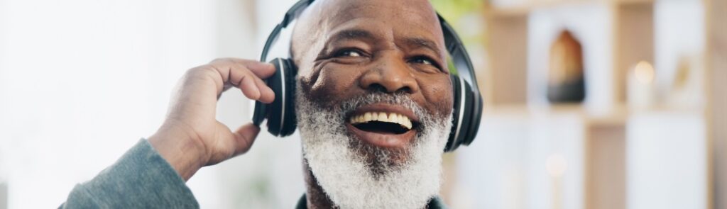 Smiling man listening to music through headphones