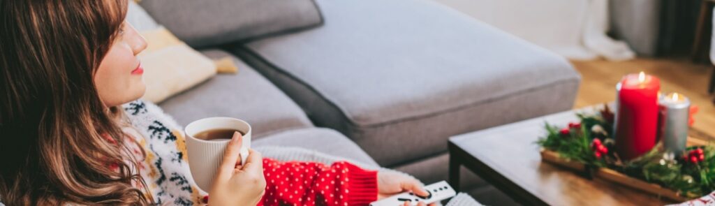 A woman relaxing wearing a Christmas jumper.