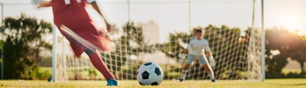 A footballer taking a shot at a goal.