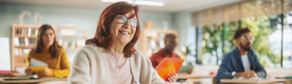Happy senior woman taking notes in a classroom