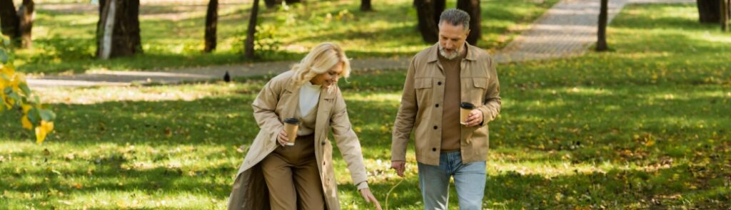 A couple and a dog walking in a park.