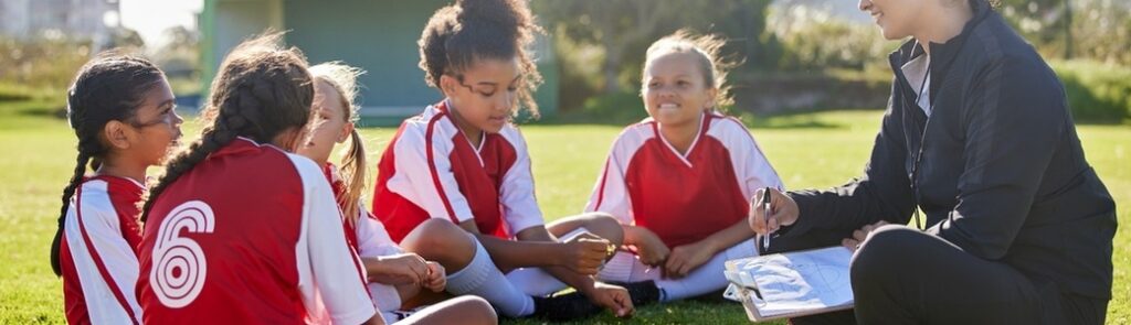 A woman coaching a girl’s football team.
