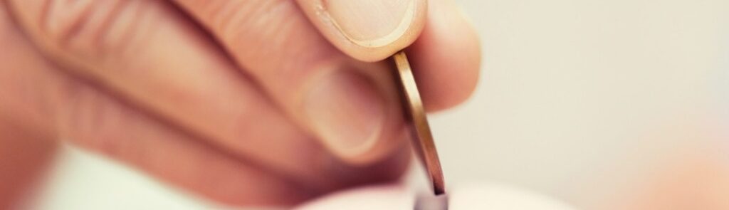 A person putting a coin into a money box.