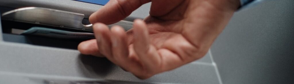 A person using an ATM to withdraw cash.