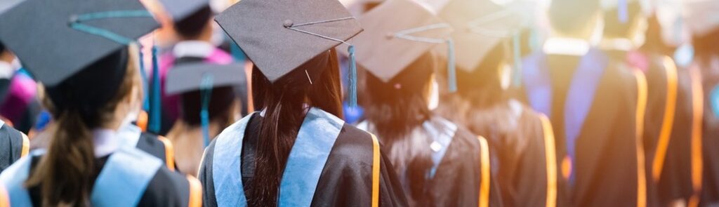 University students graduating wearing caps and gowns.