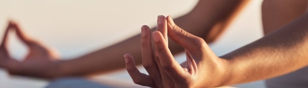 A woman sitting in the lotus position mediating.