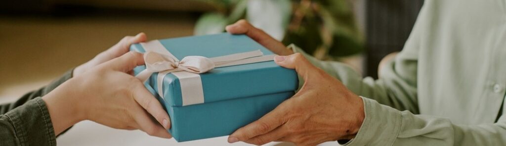 A person gifting a wrapped birthday present.