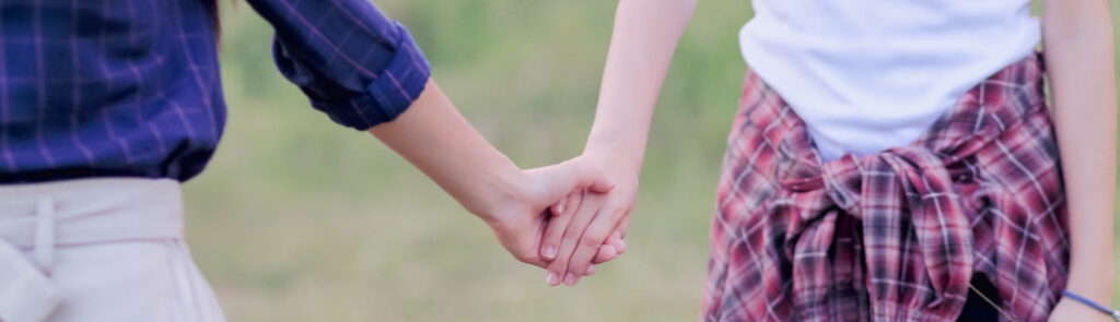 Two women holding hands.